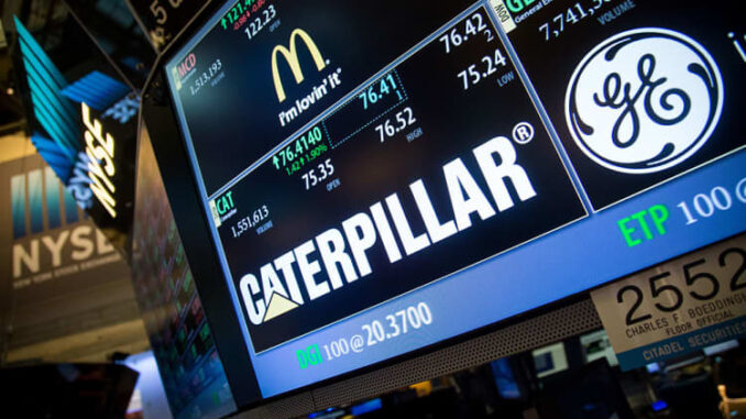 New York Stock Exchange screen prominently featuring the Caterpillar logo and stock info, along with GE and McDonalds